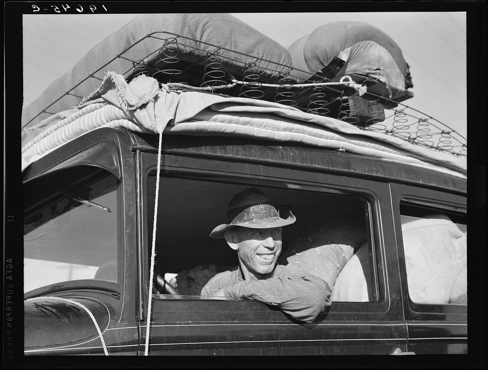 Between Tulare and Fresno on U.S. 99. Farmer from Independence, Kansas, on the road at cotton chopping time. He and his…
