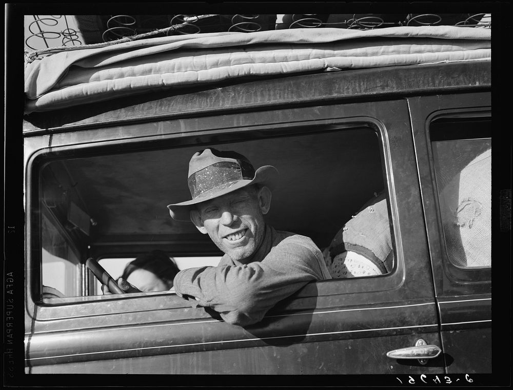 Between Tulare and Fresno on U.S. 99. Farmer from Independence, Kansas, on the road at cotton chipping time. He and his…