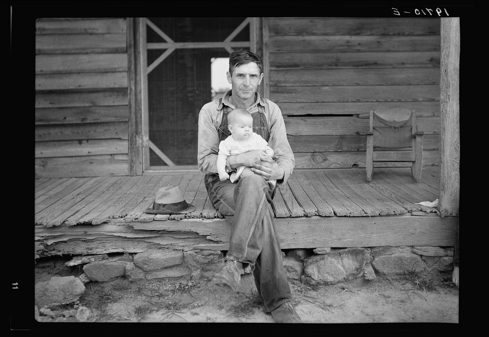 [Untitled photo, possibly related to: Mr. Whitfield, tobacco sharecropper, with baby on front porch. North Carolina, Person…