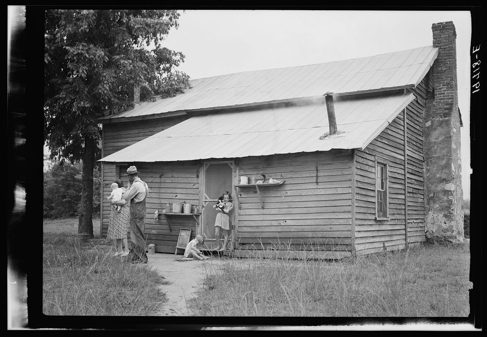 Tobacco sharecropper and his family at the back of their house showing kitchen door, household equipment, foot path to barn.…
