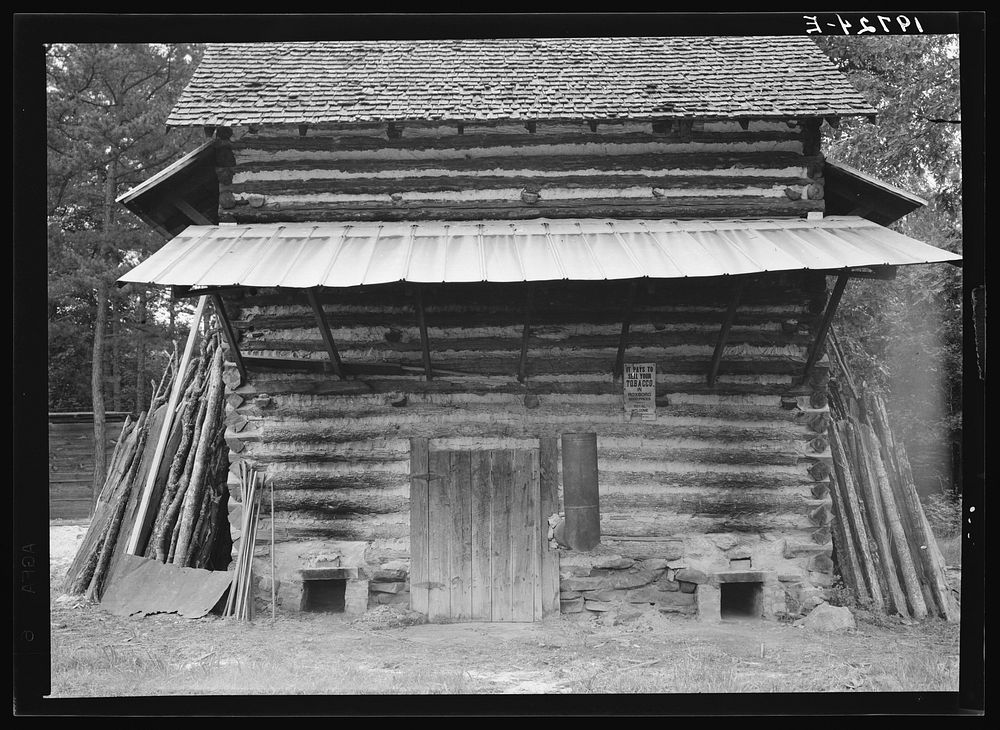 [Untitled photo, possibly related to: Tobacco barn. Person County, North Carolina. Piece of sheet iron on the left is used…