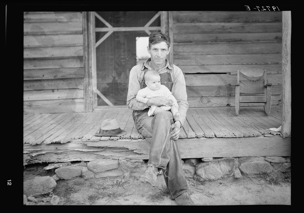 Mr. Whitfield, tobacco sharecropper, with baby on front porch. North Carolina, Person County by Dorothea Lange
