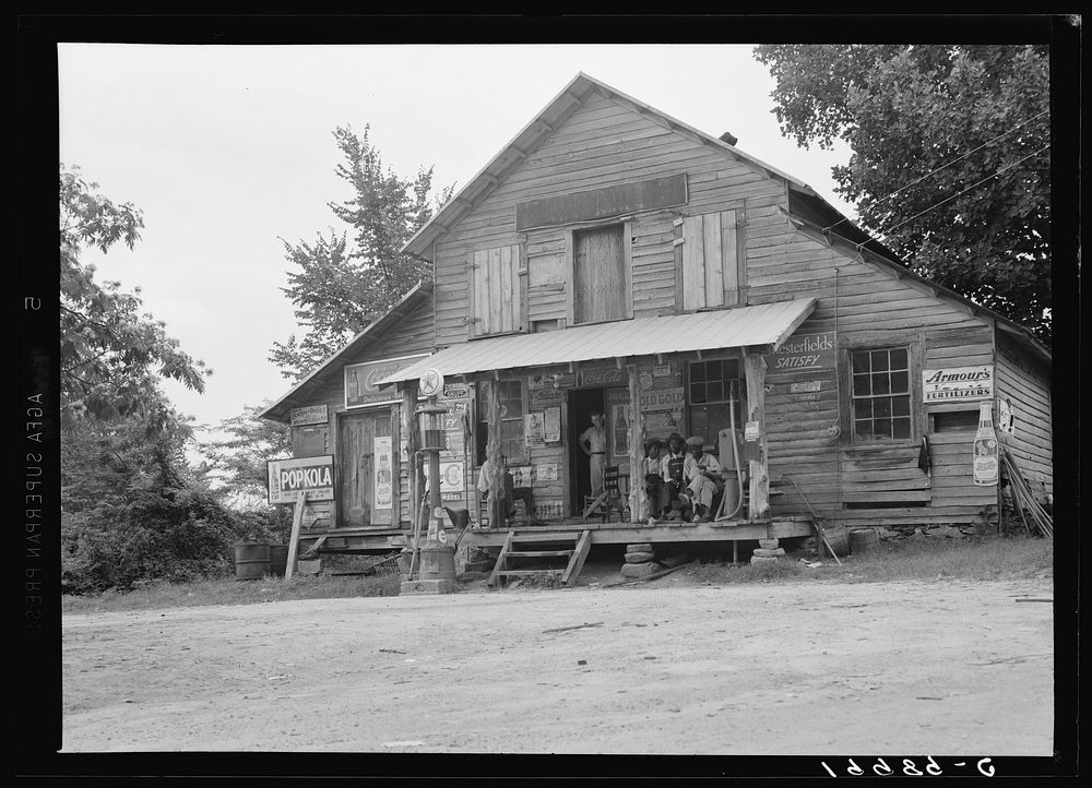 Country store on dirt road, Sunday afternoon. Note kerosene pump on right and gasoline pump on the left. The brother of the…