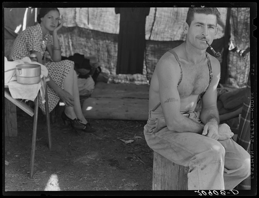 Unemployed lumber worker goes with his wife to the bean harvest. Note social security number tattooed on his arm. Oregon.…