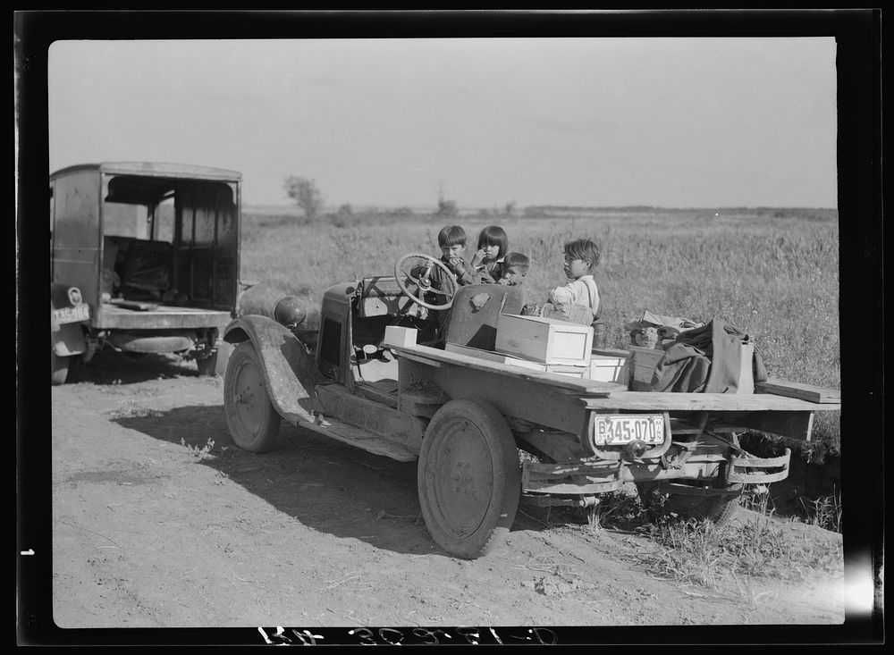 Children of Indian blueberry pickers in truck. Note boxes for blueberries and clothes. Near Littlefork, Minnesota by Russell…