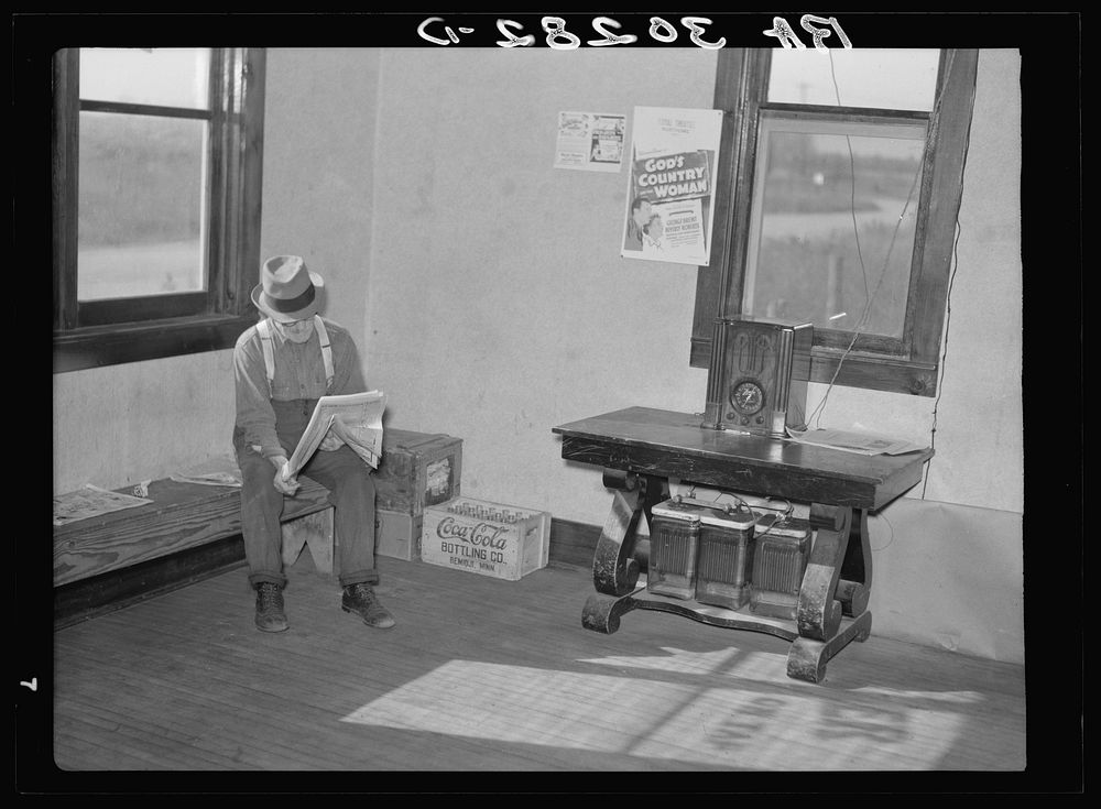Old resident of corner of beer parlor. Gemmel, Minnesota. Former prosperous lumbering center. Note sign and battery-operated…
