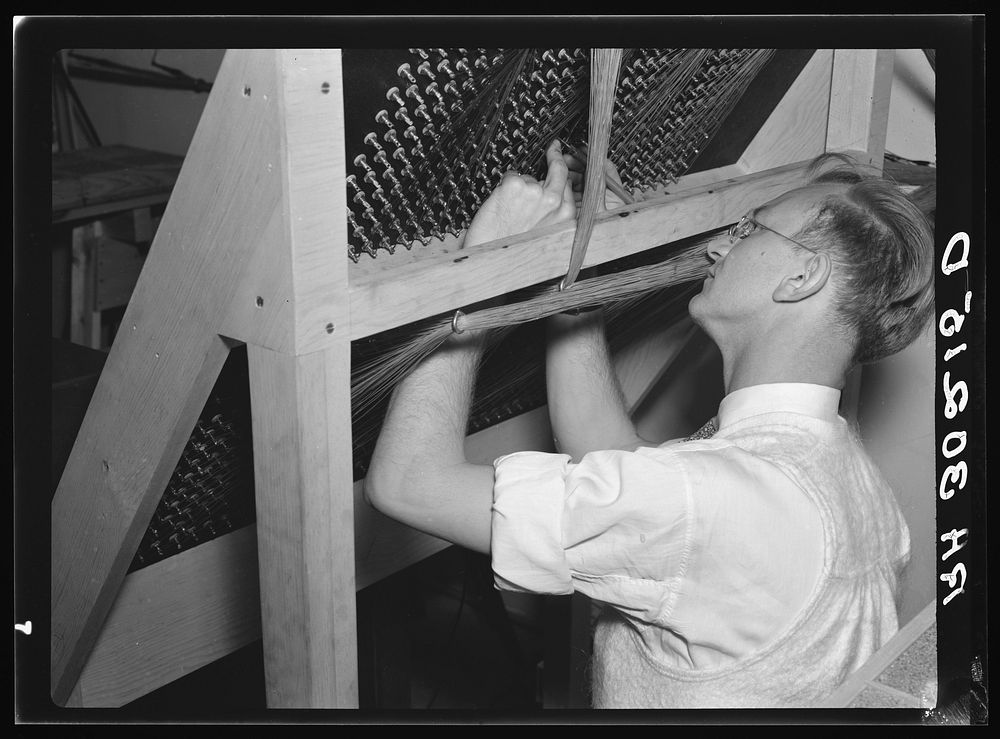 Operator making repairs on back of switchboard panel. Forest Products laboratory. Madison, Wisconsin by Russell Lee