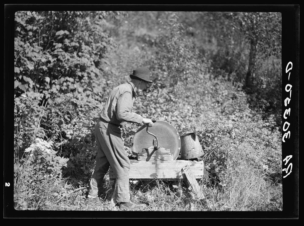 [Untitled photo, possibly related to: William Besson, old iron ore prospector, grinding an axe near Winton, Minnesota] by…