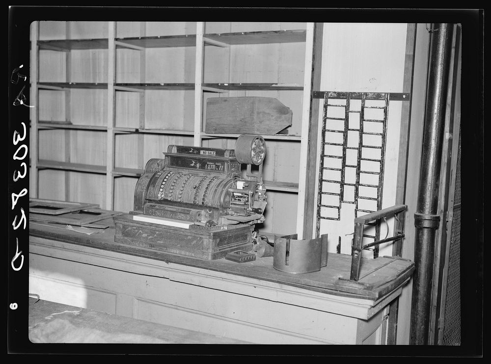 Cash register and empty shelves in closed store. Babbitt, Minnesota, "bust" iron mining town by Russell Lee