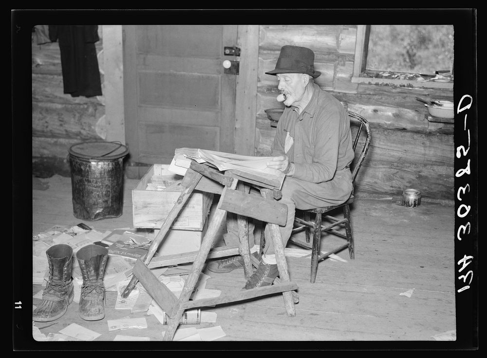 William Besson, veteran iron ore prospector and timber cruiser, examining geological surveys in his cabin near Winton…