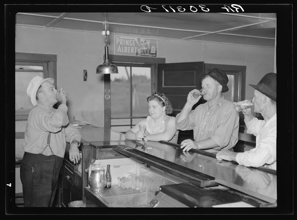 A drink on the house. Lumberjacks, proprietor and lady attendant in saloon. Craigville, Minnesota by Russell Lee