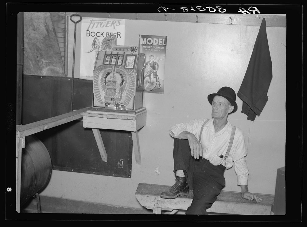 Lumberjack and slot machine in saloon. Craigville, Minnesota by Russell Lee