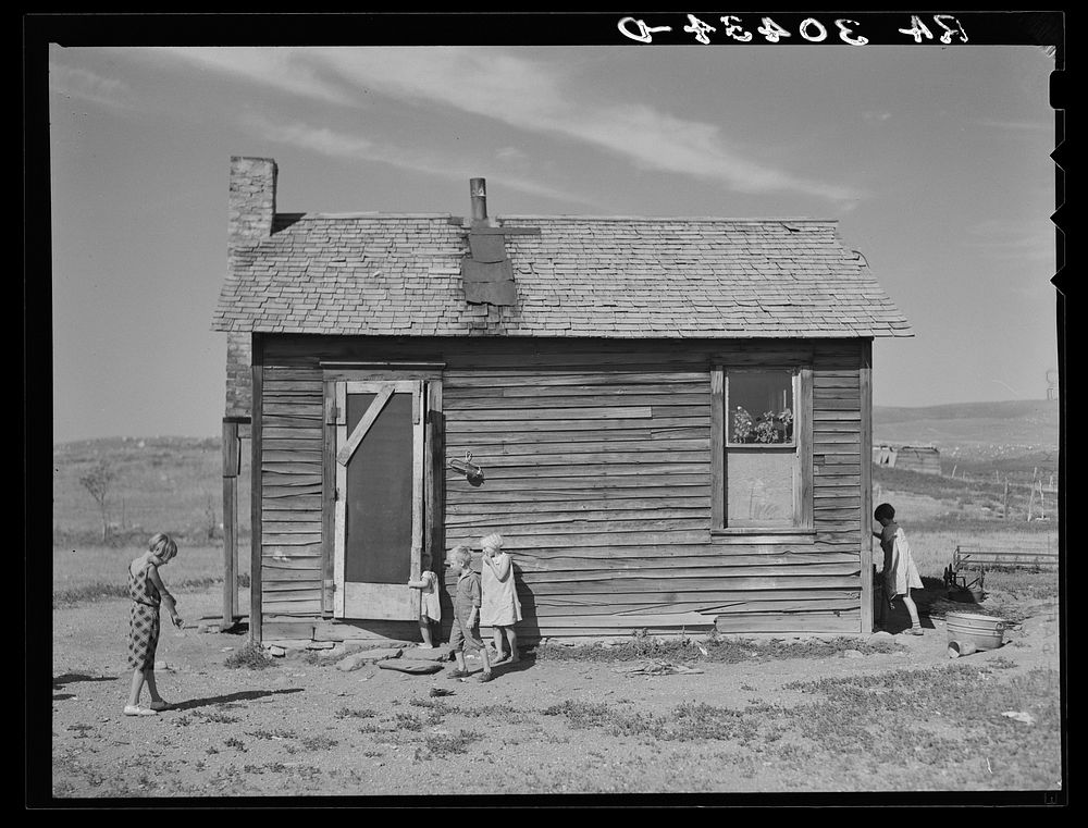 Children of Olaf Fugelberg playing in front of their home. Williams County, North Dakota by Russell Lee