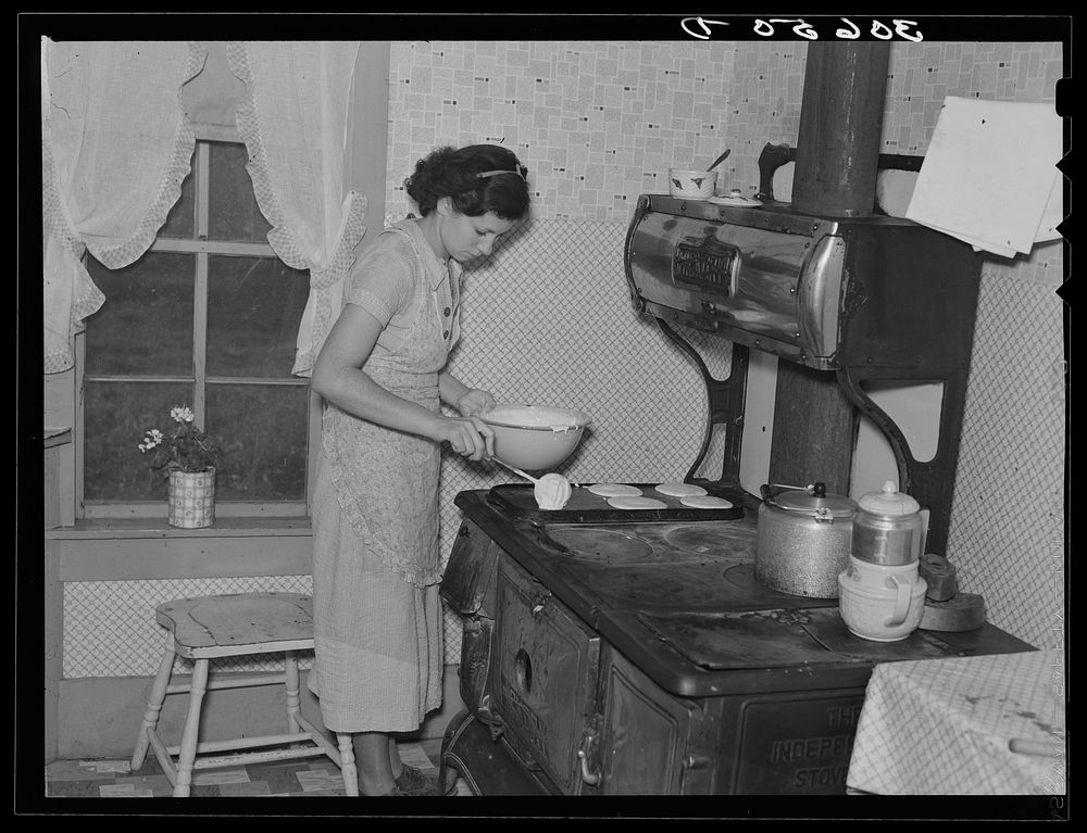 Mrs. Orville White making pancakes for breakfast near Northome, Minnesota by Russell Lee