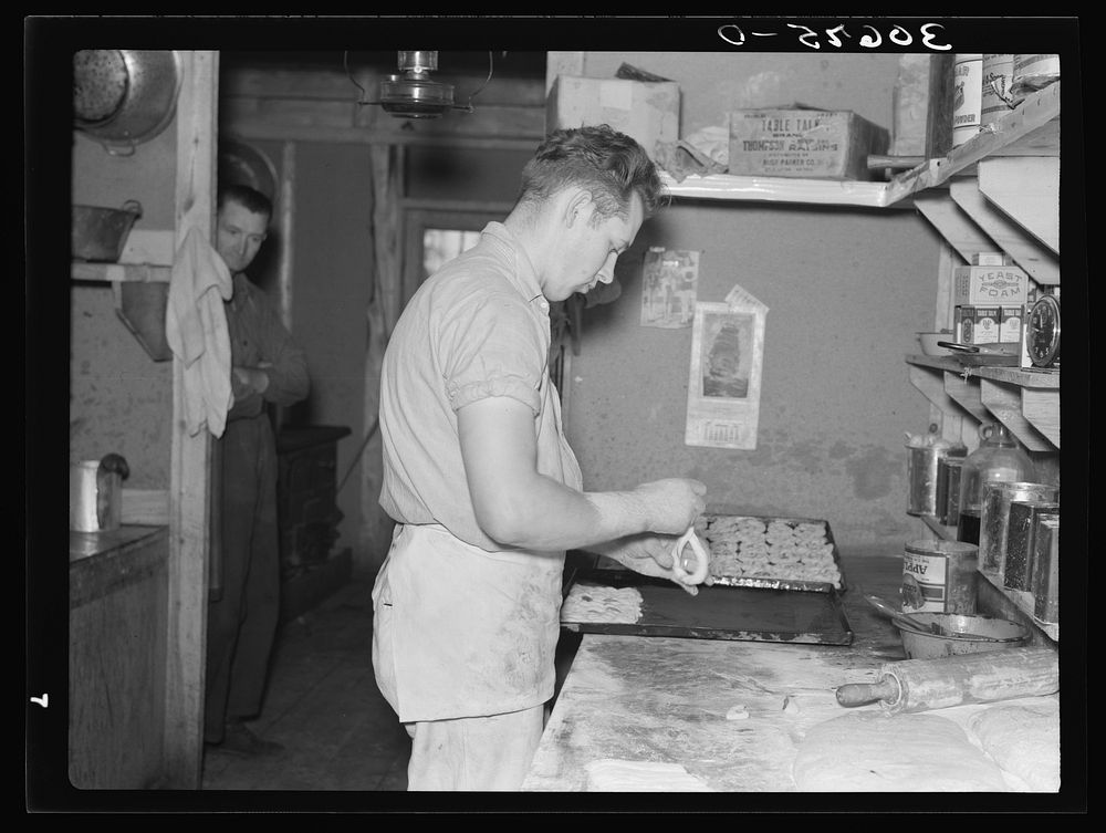 Camp cook making rolls. Logging camp near Effie, Minnesota by Russell Lee
