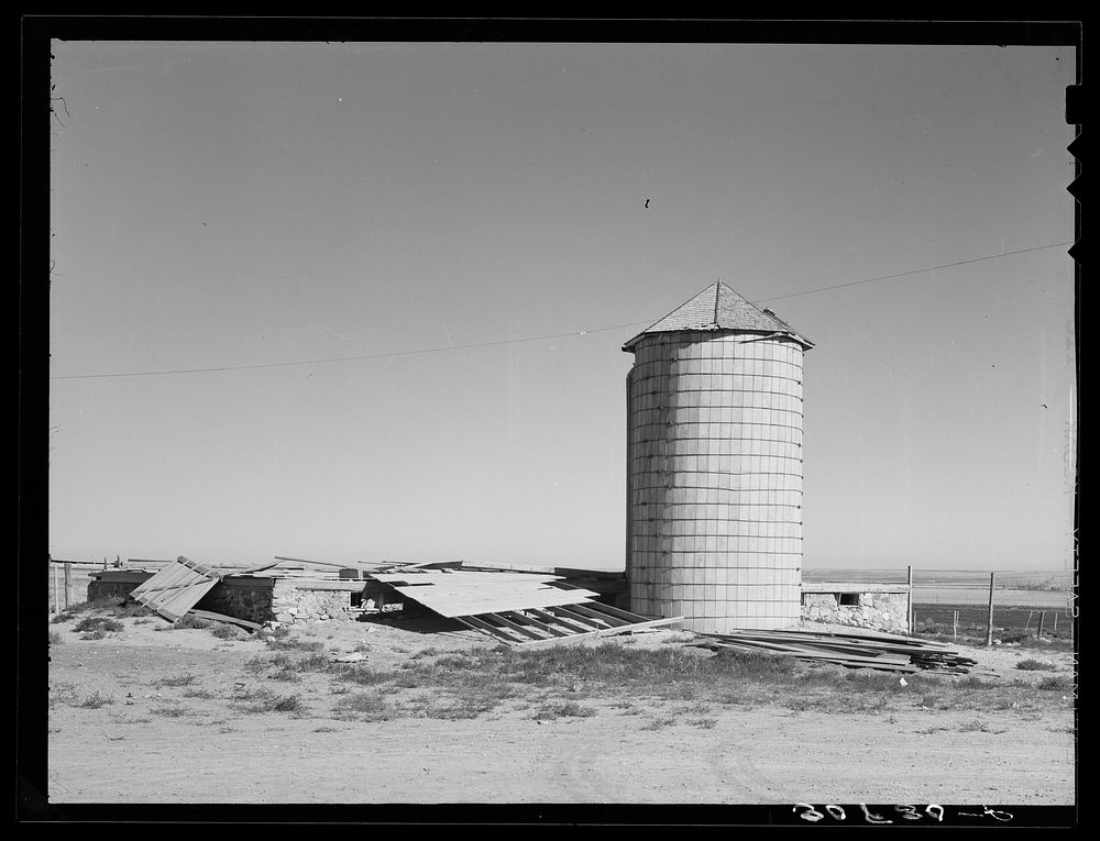 Old silo and remains of barn wrecked by wind near Williston, North Dakota by Russell Lee