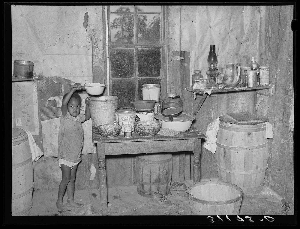 New Madrid County, Missouri. Child of sharecropper getting drink of water in kitchen of shack by Russell Lee