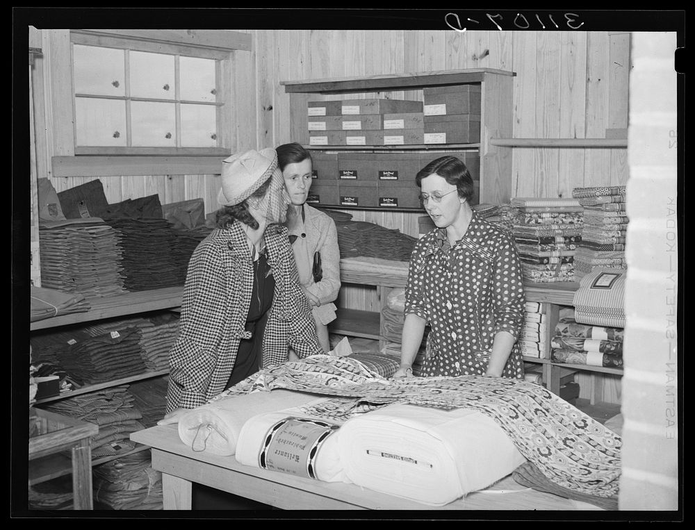 Southeast Missouri Farms. Customers examining yard goods in cooperative store. La Forge project, Missouri by Russell Lee