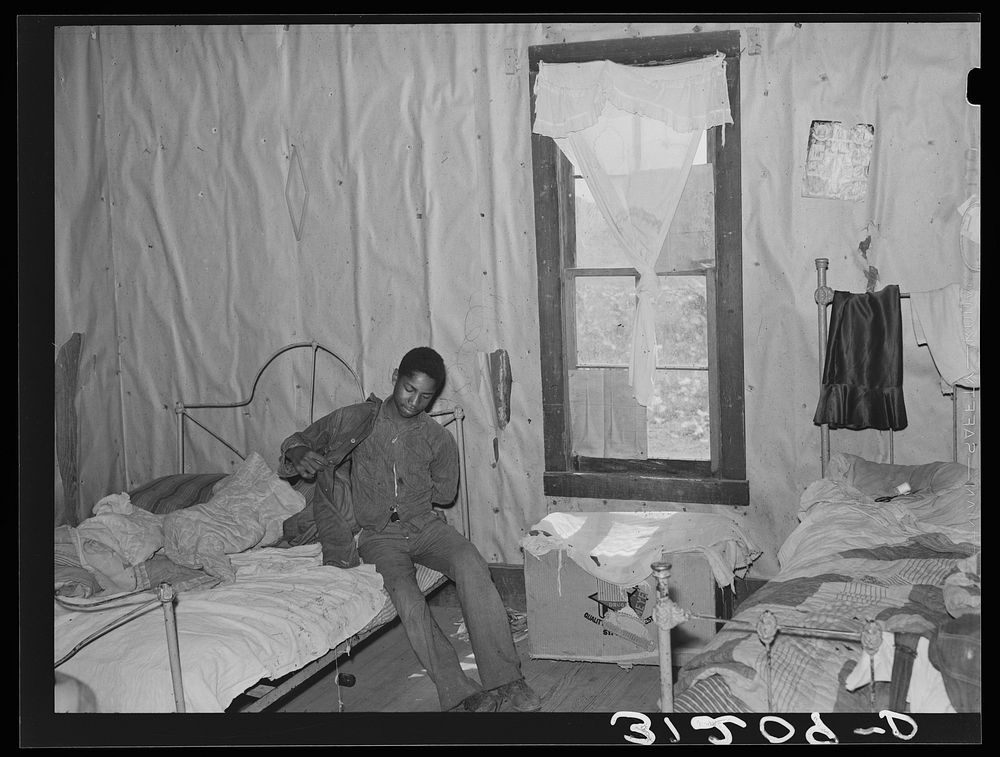 Southeast Missouri Farms. Son of sharecropper getting dressed in bedroom shack by Russell Lee