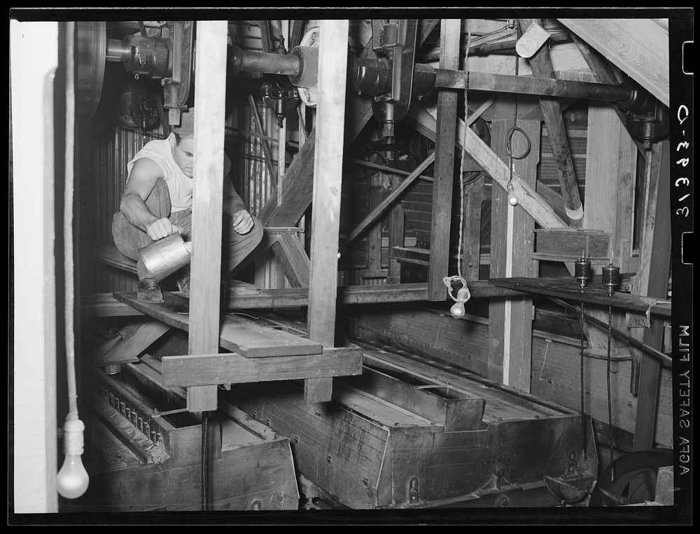 Man oiling machine used for screening rice. State rice mill, Crowley, Louisiana by Russell Lee