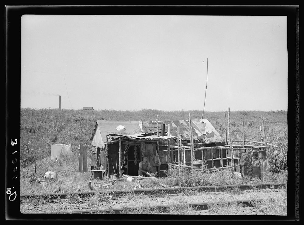 Shack on the other side of the railroad tracts, looking toward the levee. Tin Town, Caruthersville, Missouri by Russell Lee