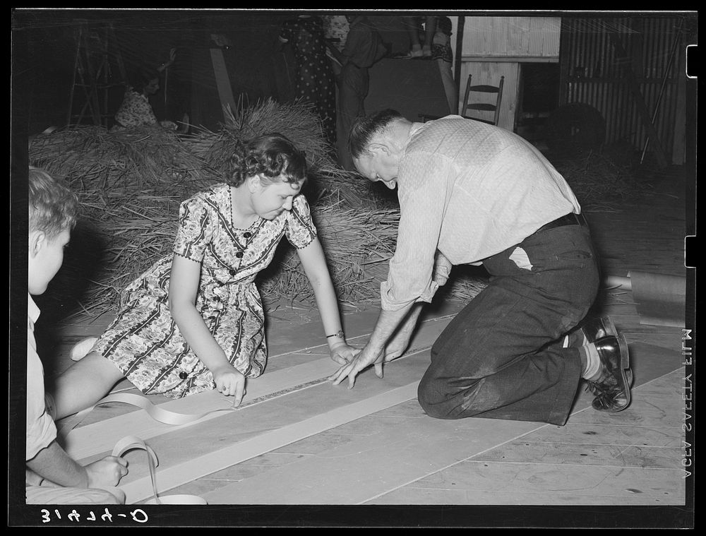 Cutting strips of  paper to use in decorating float, National Rice Festival, Crowley, Louisiana by Russell Lee