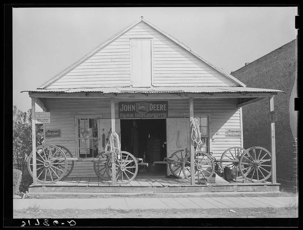[Untitled photo, possibly related to: Wagons on porch of farm implements dealer. Erath, Louisiana] by Russell Lee
