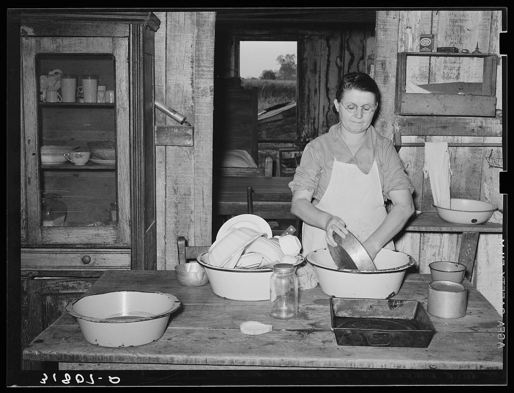 Mrs. M. LaBlanc washing dishes in kitchen of her present home. Morganza, Louisiana by Russell Lee