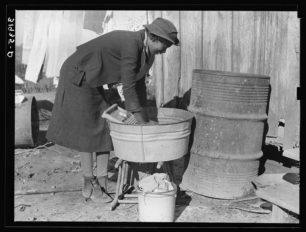 Washing clothes at rear of sharecropper's cabin. Transylvania, Louisiana by Russell Lee