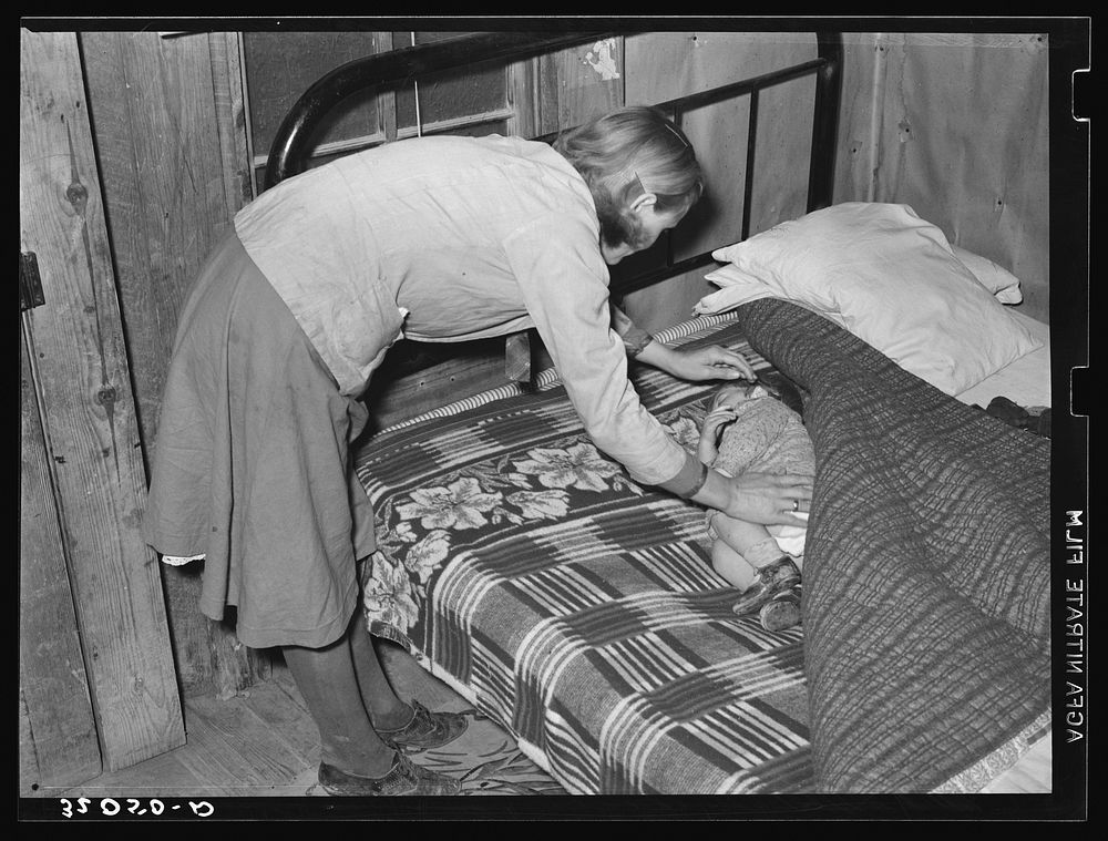Wife of sharecropper putting baby to sleep near Pace, Mississippi. Background photo, Sunflower Plantation by Russell Lee