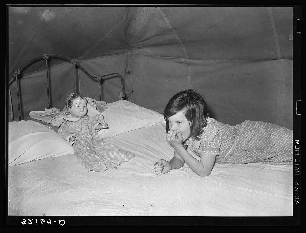 Child migrant with doll in tent home. Harlingen, Texas by Russell Lee