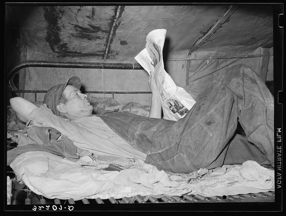 Migrant worker on bed in tent home. Mercedes, Texas. See 32108-D by Russell Lee