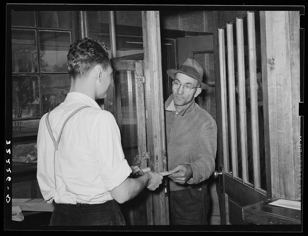 Farmer receiving check for sweet potatoes at starch plant. Laurel, Mississippi by Russell Lee