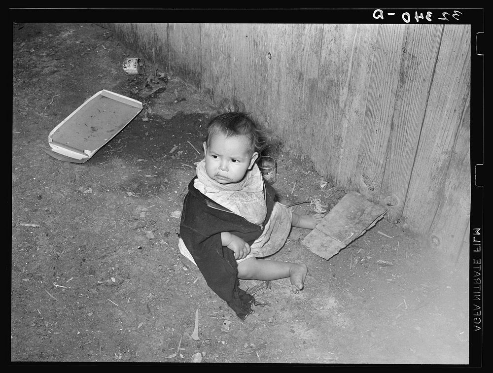Mexican child playing outside of corral in dirt. Robstown, Texas by Russell Lee