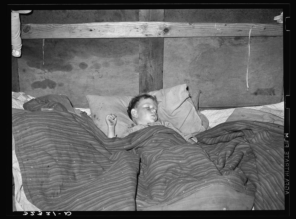 [Untitled photo, possibly related to: A sick child sleeping in trailer home of his father near Sebastian, Texas. This family…