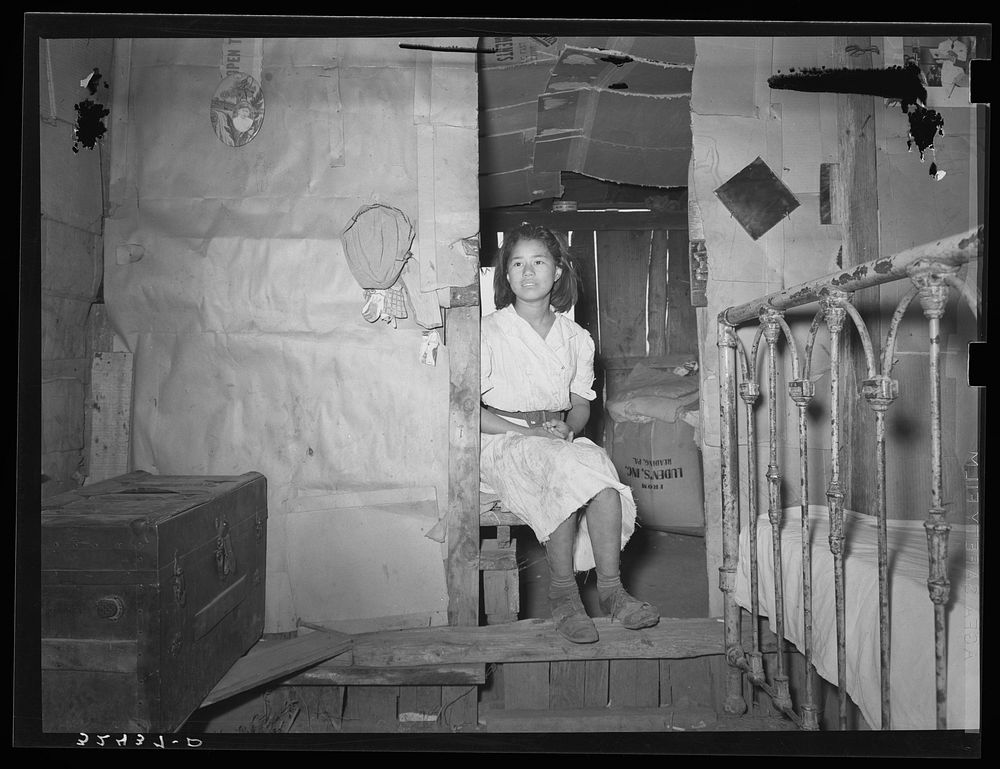 Mexican girl sitting in doorway between living room and bedroom. San Antonio, Texas by Russell Lee