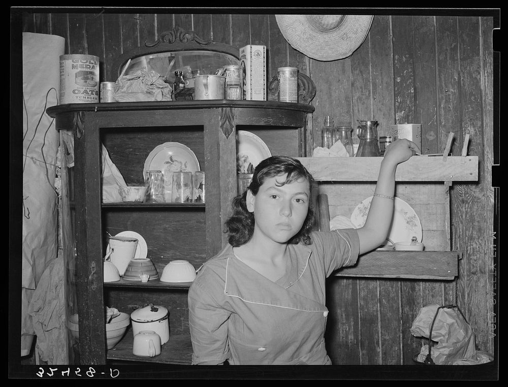 Mexican girl standing in front of dish cupboard. San Antonio, Texas by Russell Lee