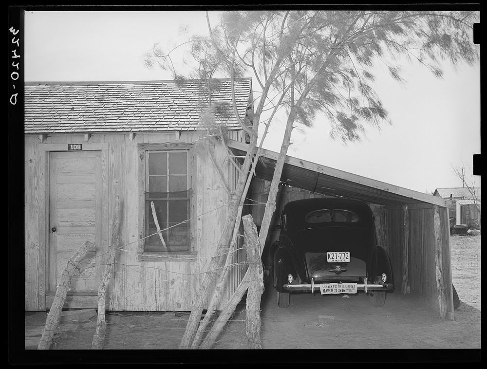 House, garage and new car of Mexican. Crystal City, Texas. It is common practice for the Mexicans on returning from the beet…