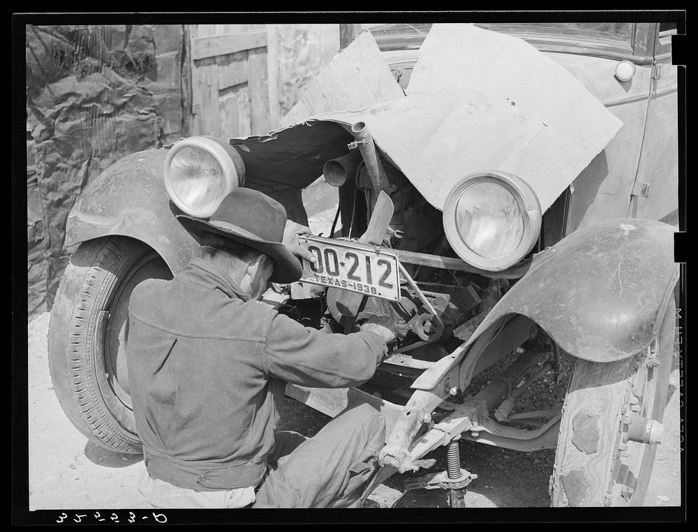 Mexican repairing automobile. San Antonio, Texas. Notice the worn-out tires by Russell Lee