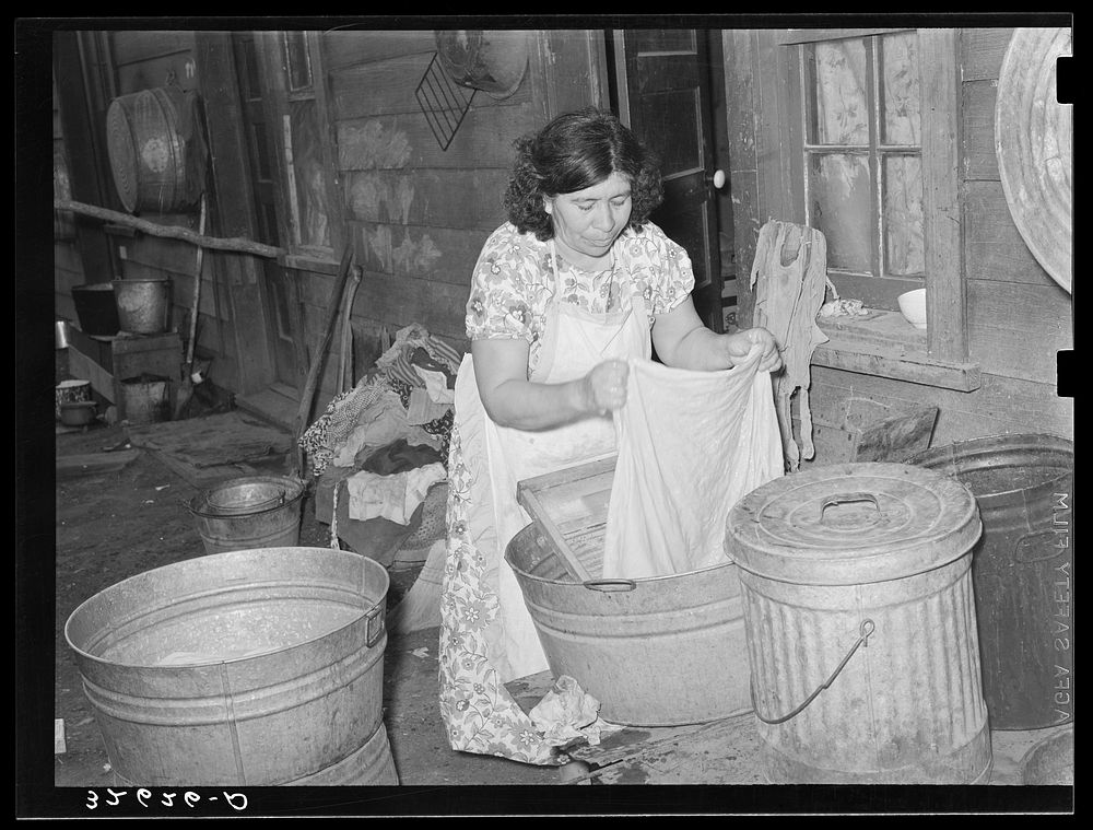 Mexican woman washing in front of house in corral. Mexican section, San Antonio, Texas by Russell Lee