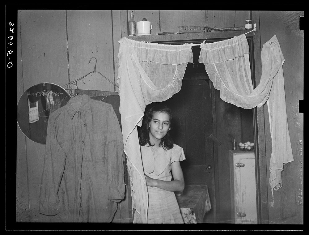Mexican girl in doorway between living room and kitchen. San Antonio, Texas by Russell Lee