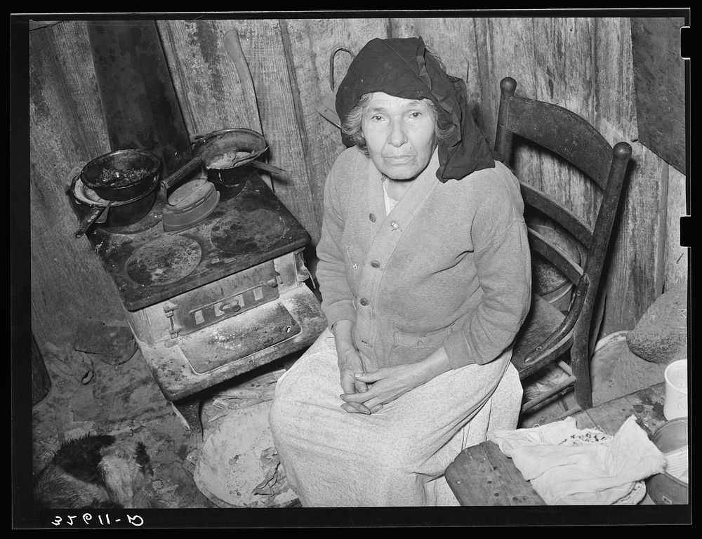 Mexican woman sitting in front of stove. San Antonio, Texas by Russell Lee