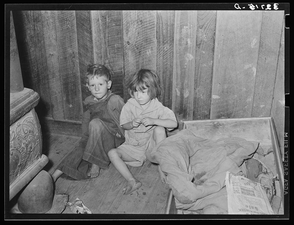 Two children of family living on relief near Jefferson, Texas. These children did not attend school because of lack of warm…