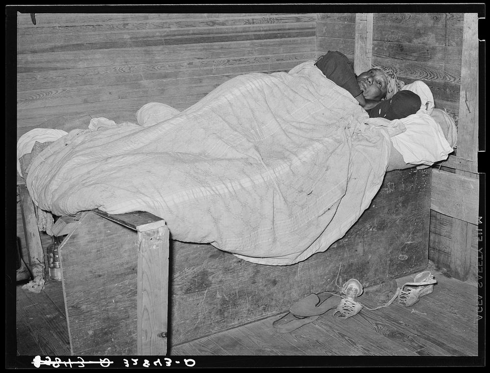  woman sick in bed in strawberry pickers' quarter. Independence, Louisiana by Russell Lee