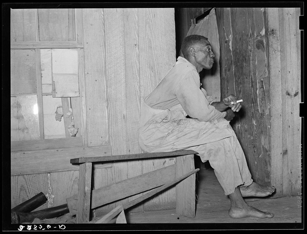Strawberry sharecropper on front porch of his home near Hammond, Louisiana. He said that in a good year he came out with…