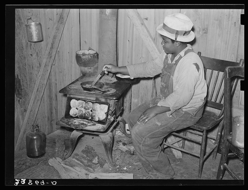  woman preparing dinner for her family. Hammond, Louisiana. This family lived on the farm and did odd jobs by Russell Lee
