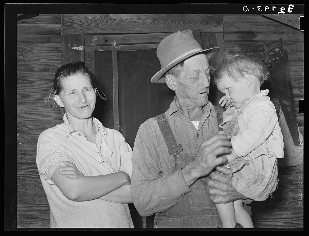 Wife and husband and child. Note condition of woman's teeth. Living on outskirts of Jefferson, Texas by Russell Lee