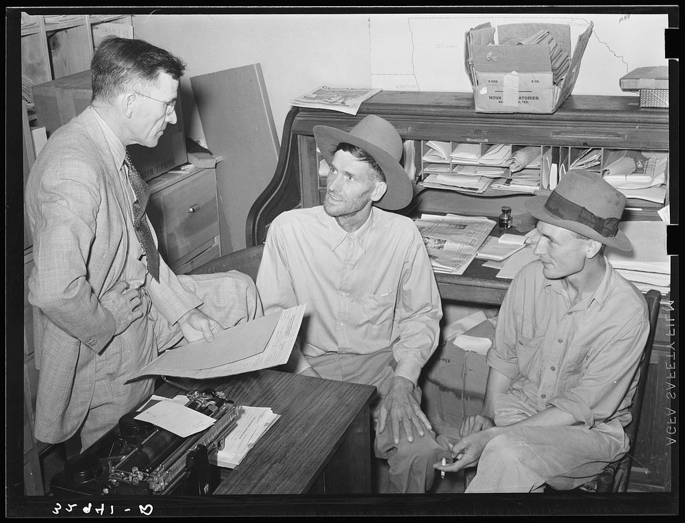 Assistant county agent talking to farmers in his office. San Augustine, Texas by Russell Lee