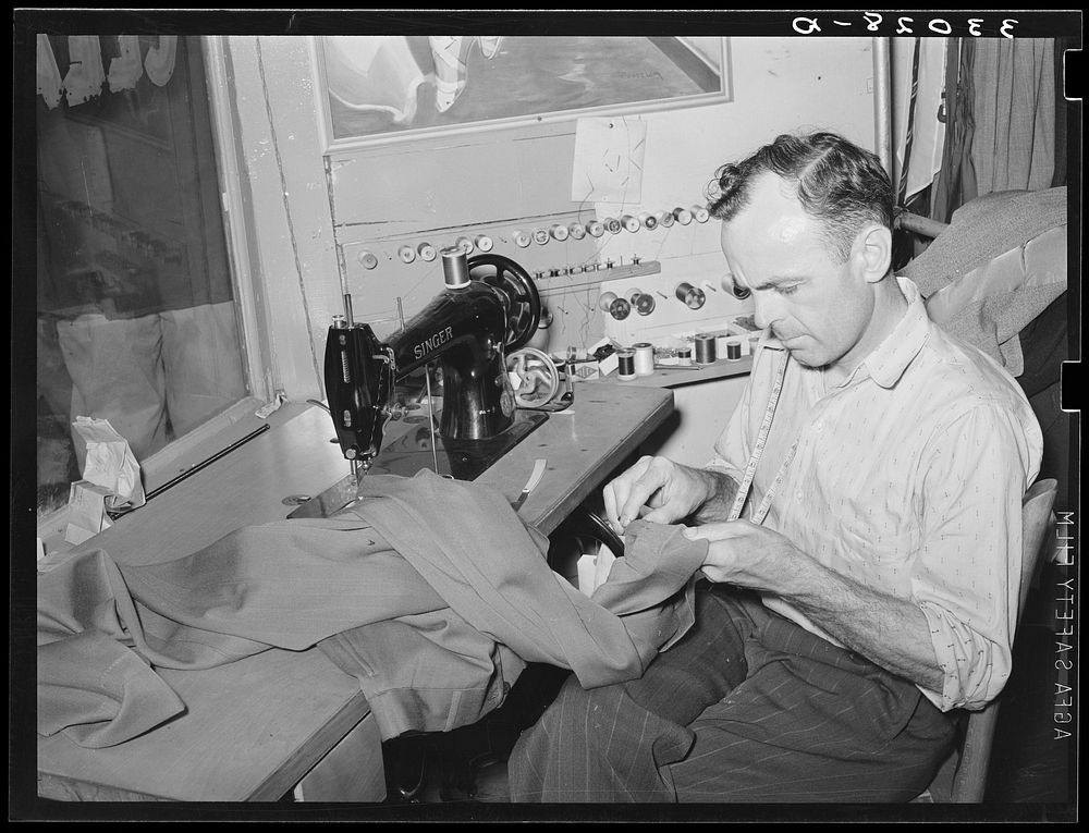 Tailor shortening a pair of trousers. San Augustine, Texas by Russell Lee