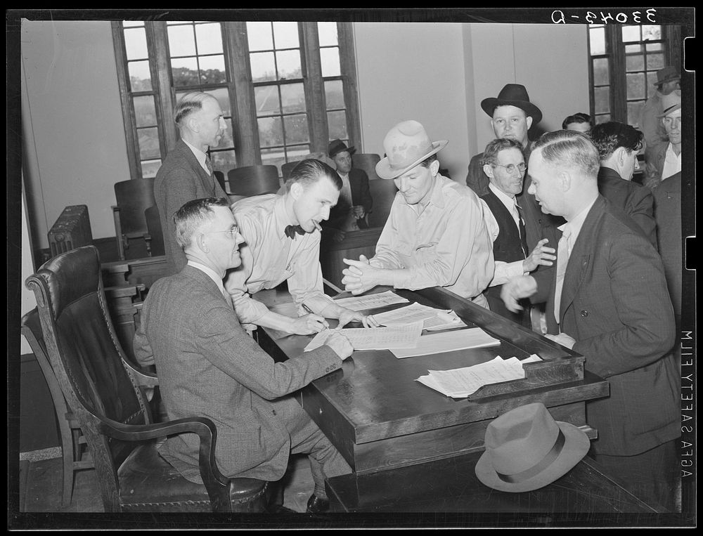 Discussion at the county judge's desk after the mass meeting. San Augustine, Texas by Russell Lee